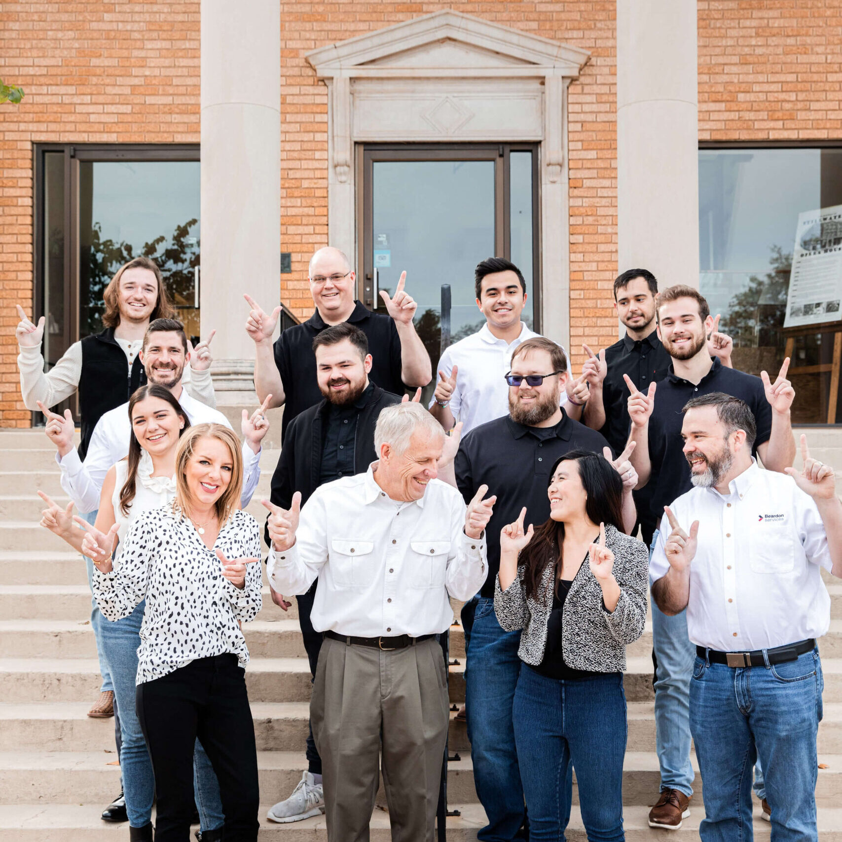 Company-photo-on-stairs-with-guns-firing-scaled